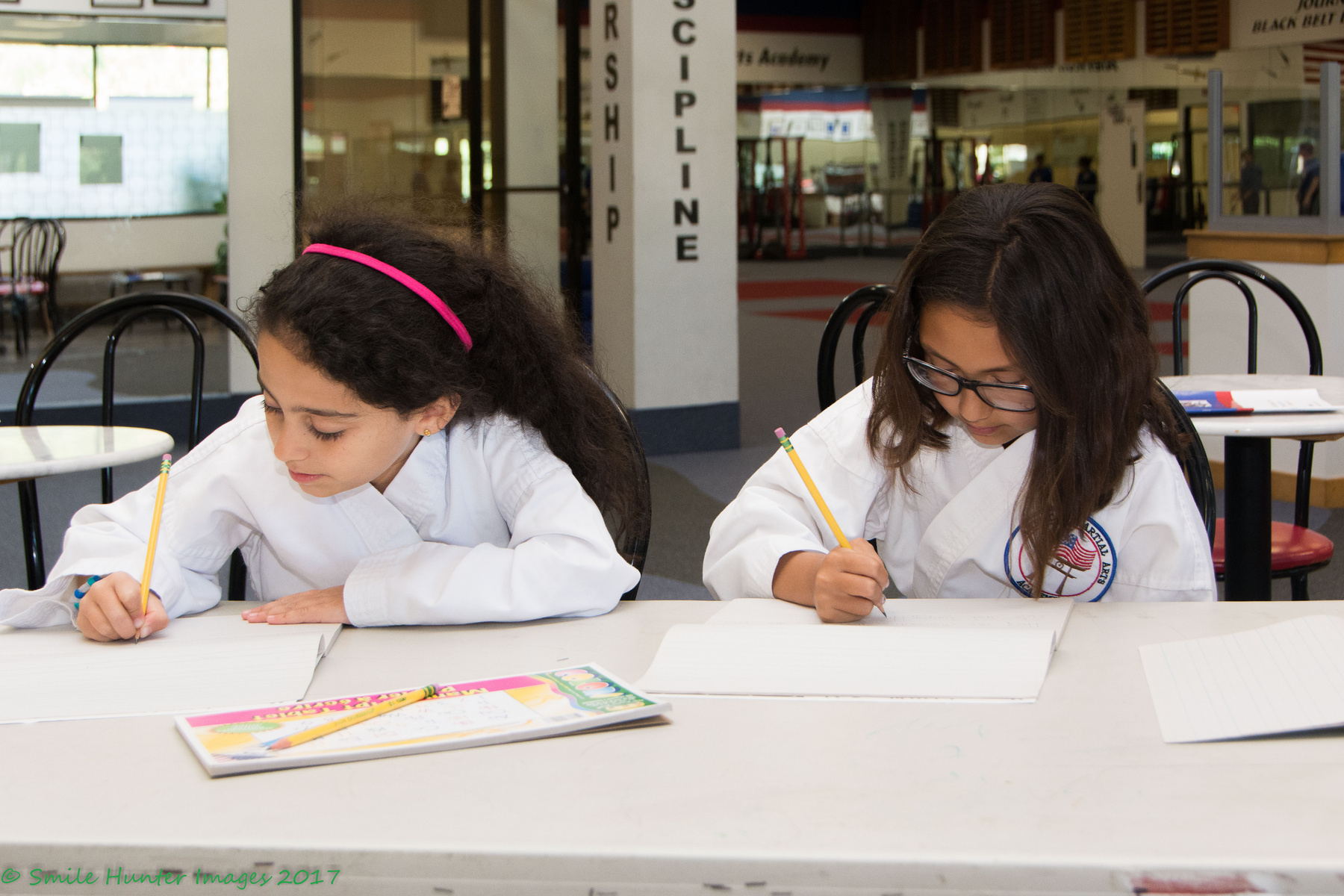 Two students at the academy working on homework at a table